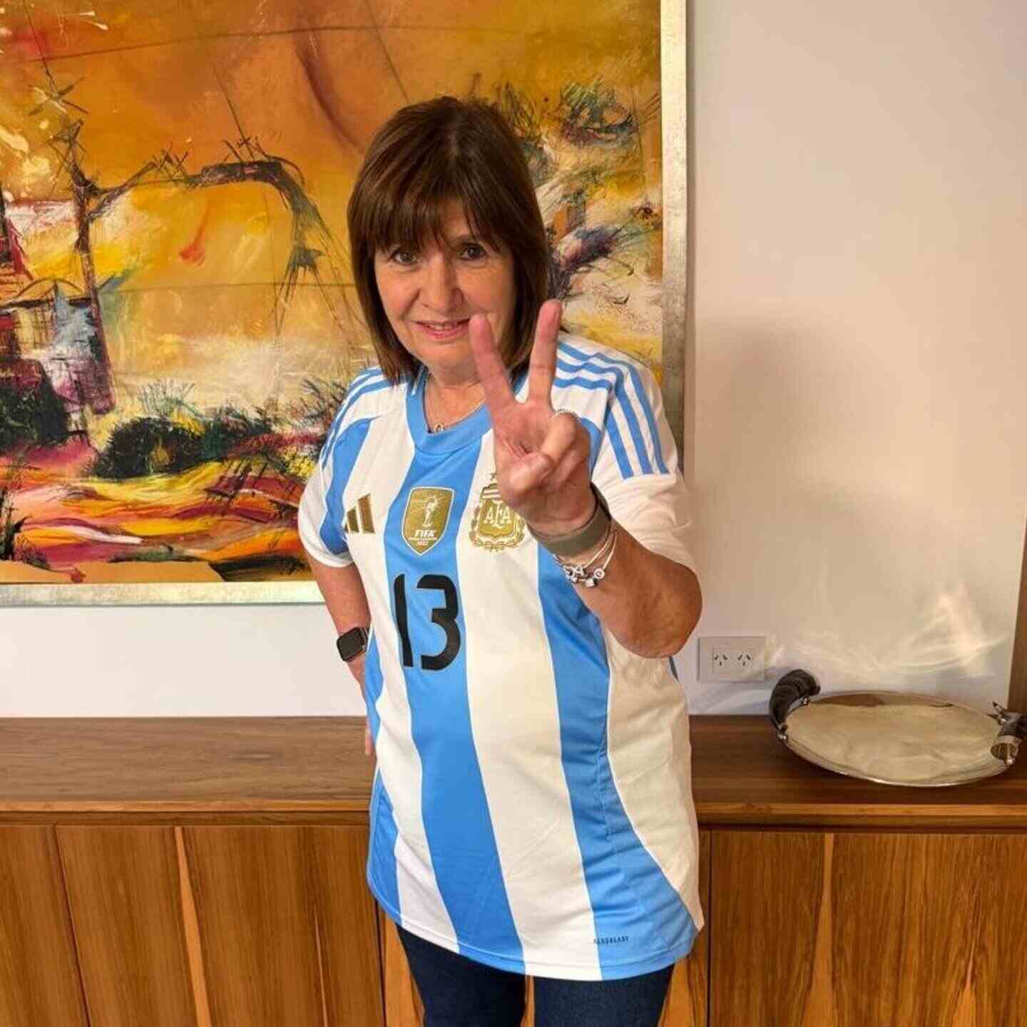 Mujer con camiseta de la Selección Argentina haciendo el signo de la paz