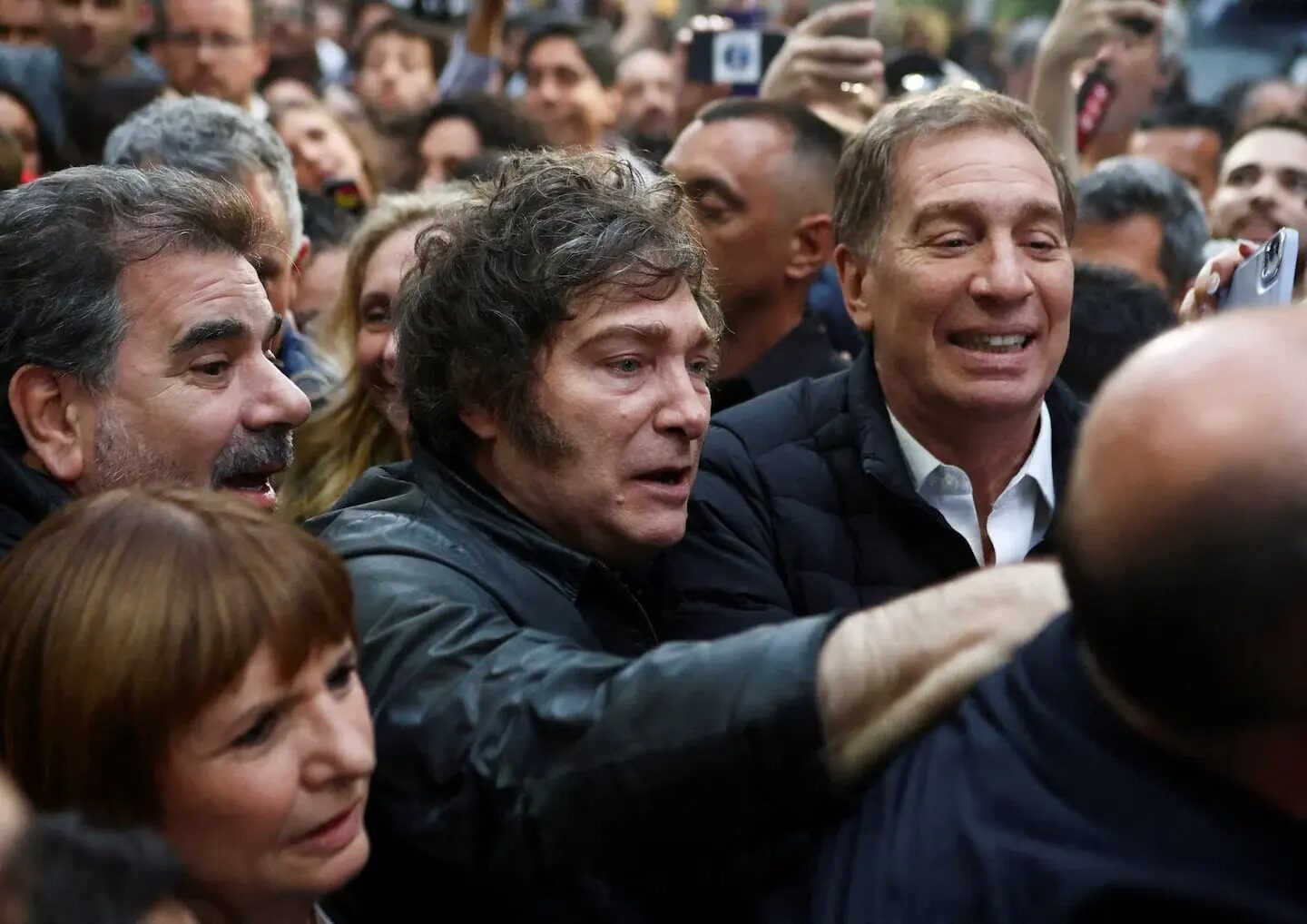 Javier Milei en un evento rodeado de simpatizantes y miembros del Gobierno argentino