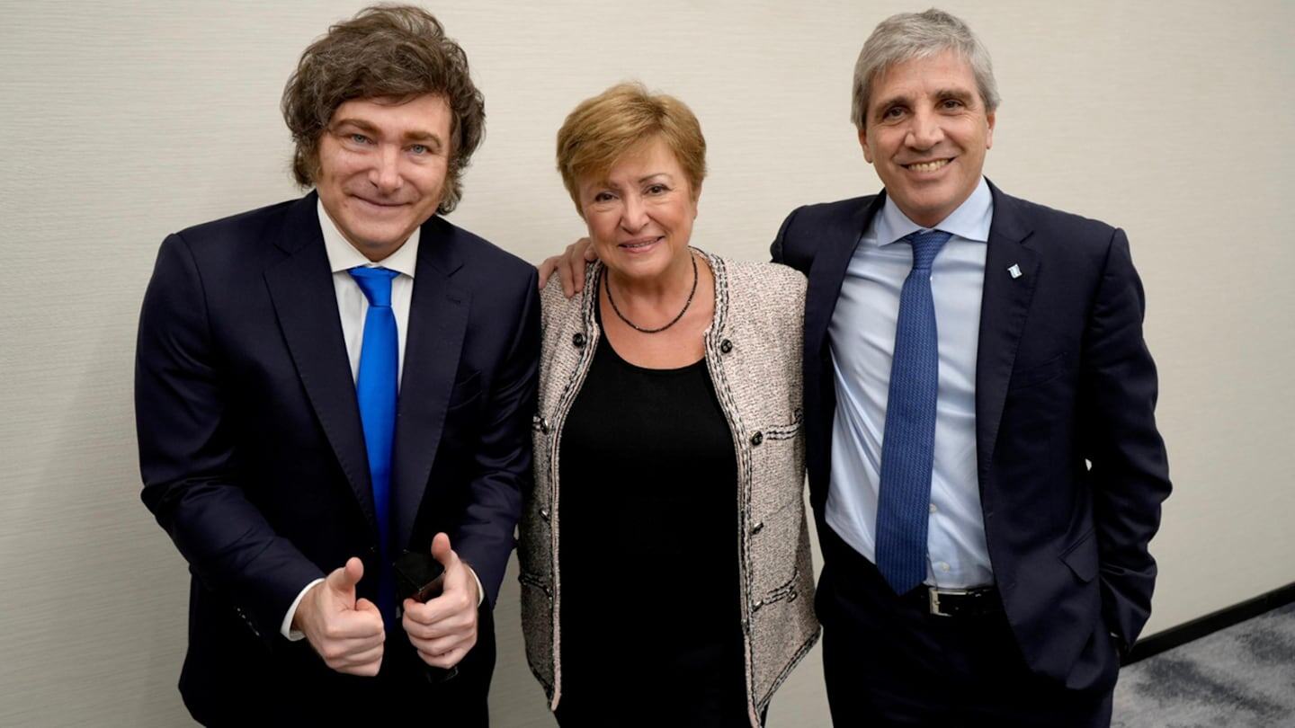 Tres personas posando para la foto, incluyendo a un hombre con cabello rizado y traje oscuro, una mujer con chaqueta clara y un hombre con c