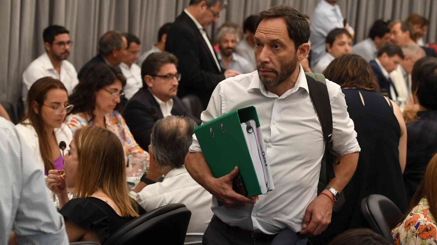 Manuel Adorni con carpeta en mano durante una reunión en el Senado