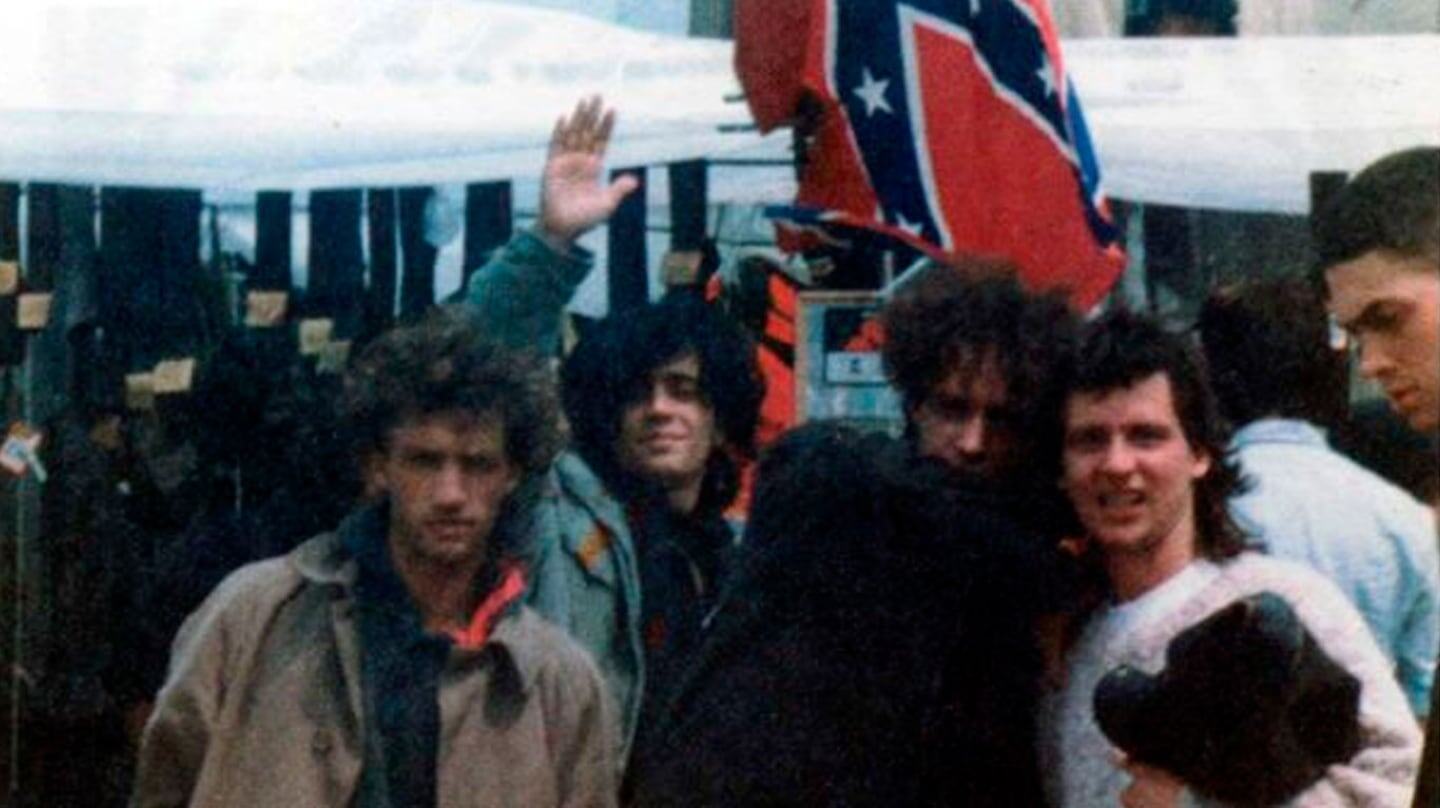 Grupo de jóvenes en un festival de rock en Londres con una bandera confederada de fondo