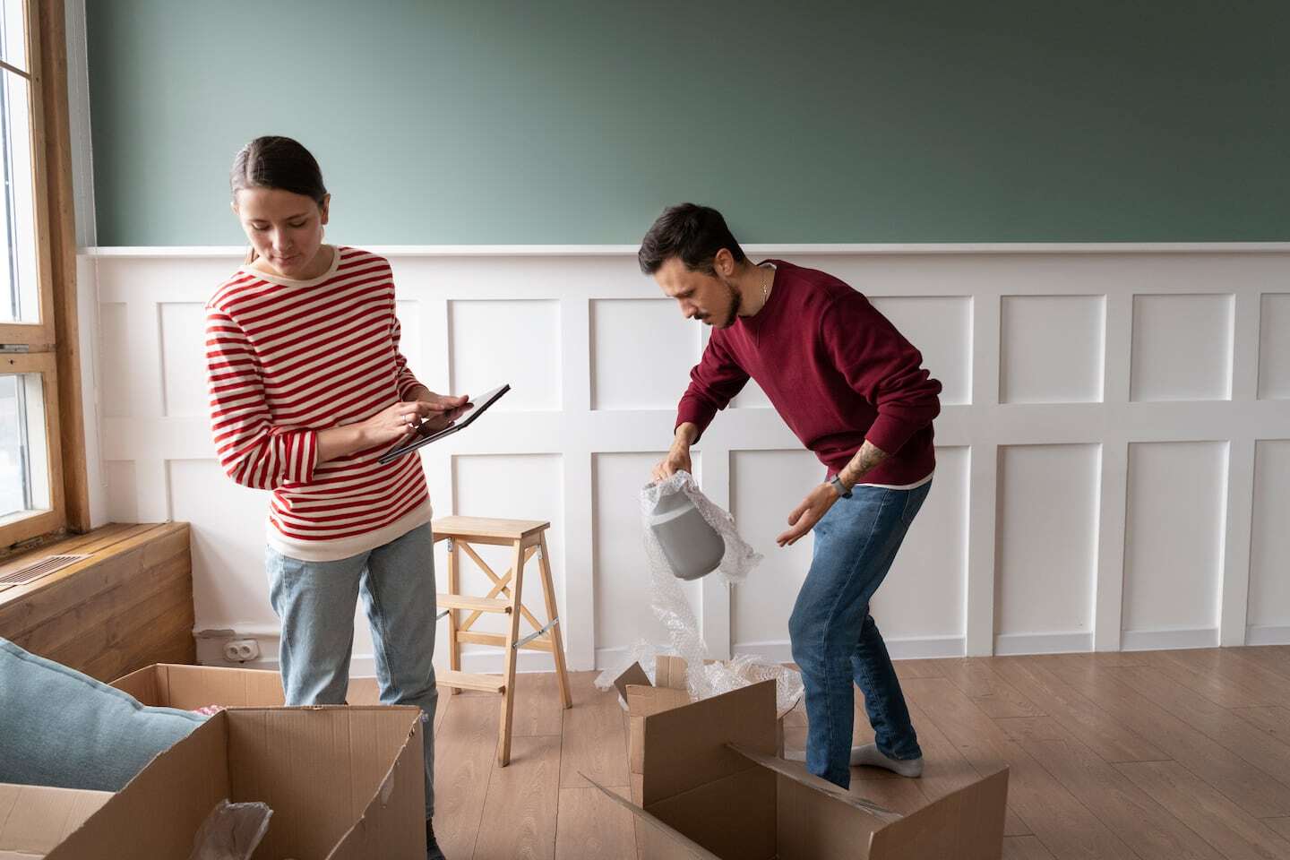 Pareja organizando su hogar con cajas y materiales de mudanza