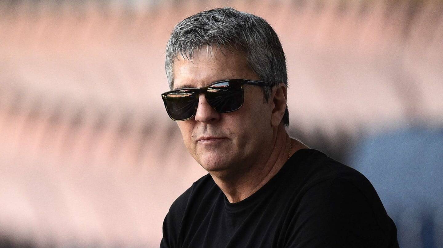 Hombre con gafas de sol y camiseta negra, mirando pensativo