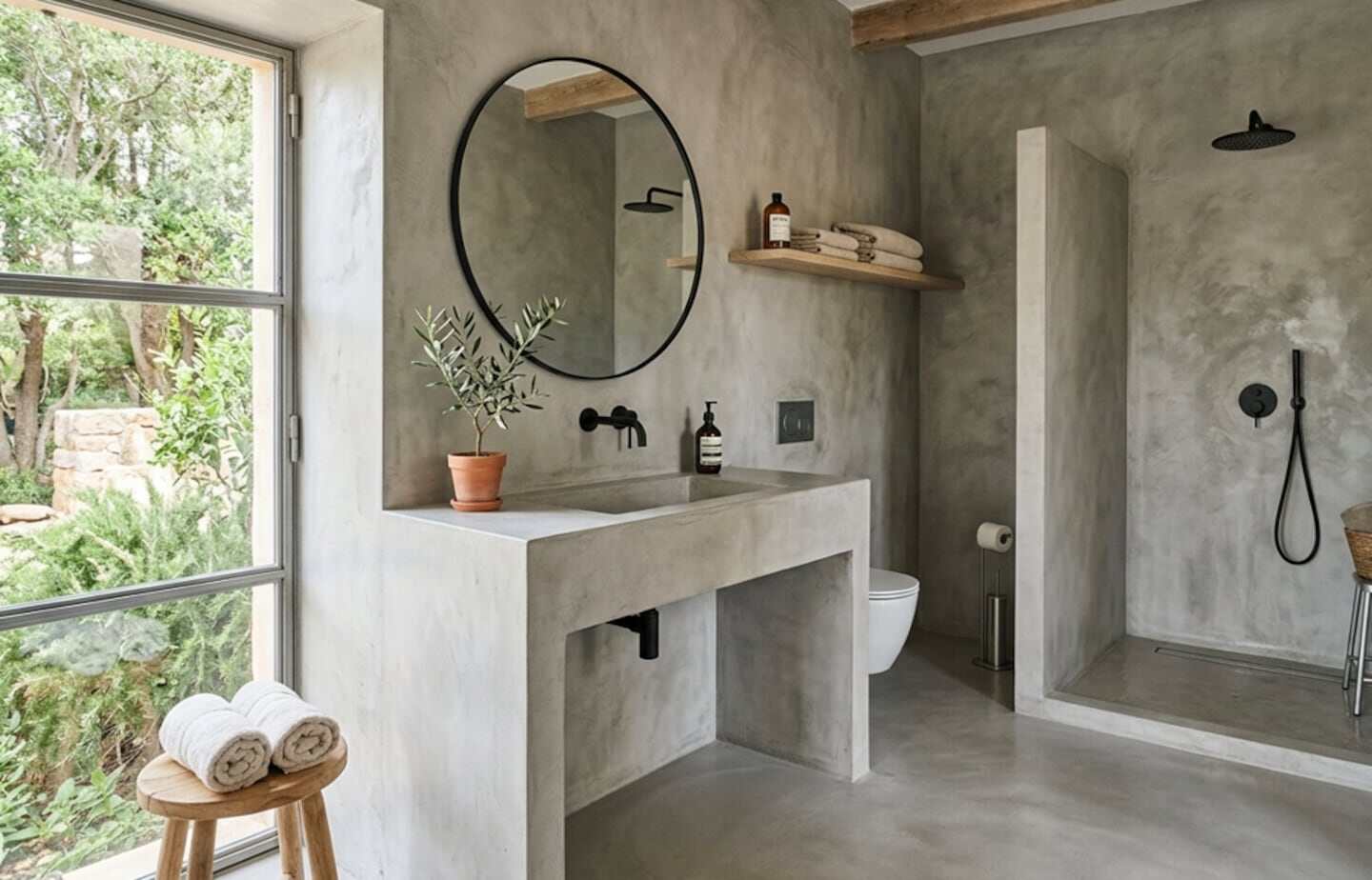 Baño moderno con microcemento en paredes y suelo, lavabo minimalista y ducha