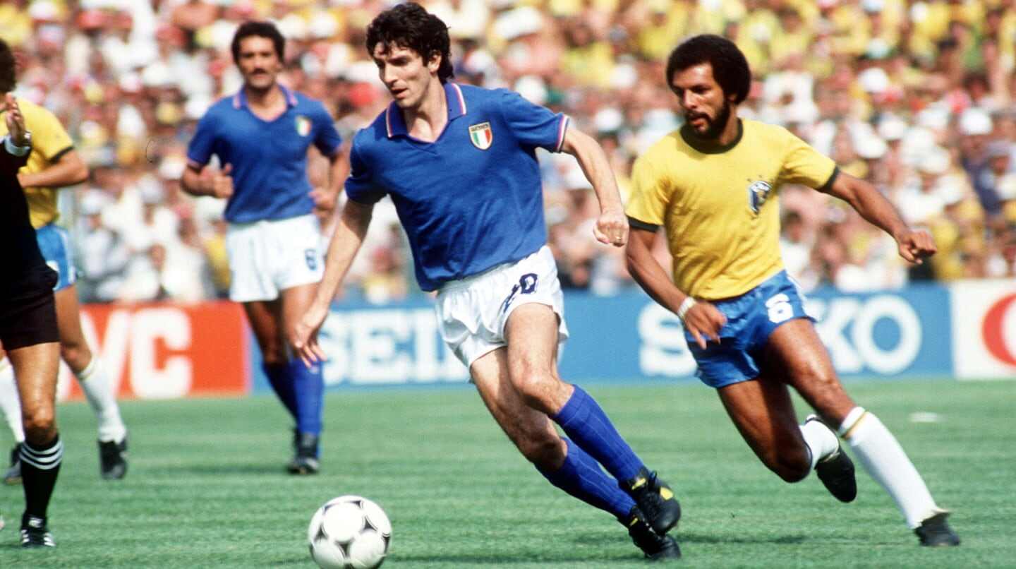 Jugador italiano avanza con el balón mientras un defensor brasileño lo persigue en un partido del Mundial