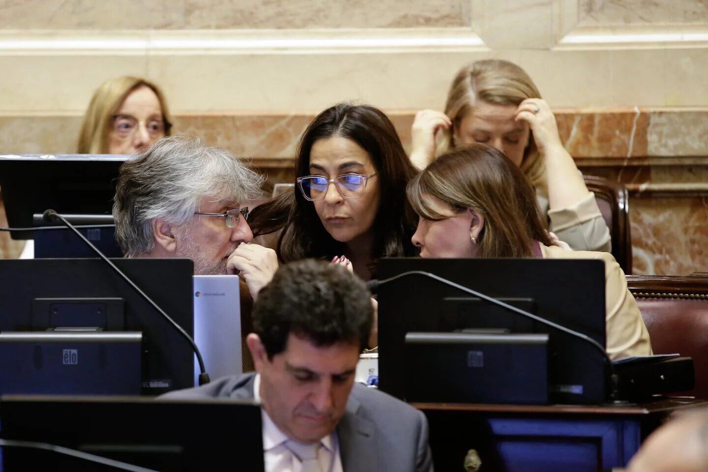 Reunión en el Senado argentino con legisladores conversando sobre la interpelación a Manuel Adorni