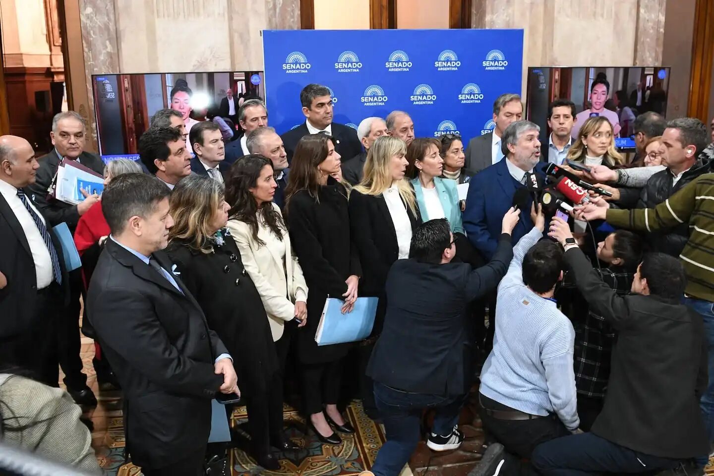 Grupo de funcionarios y legisladores en el Senado durante una conferencia de prensa sobre la interpelación a Manuel Adorni