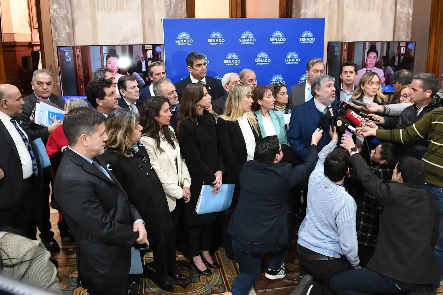 Grupo de funcionarios y legisladores en el Senado durante una conferencia de prensa sobre la interpelación a Manuel Adorni