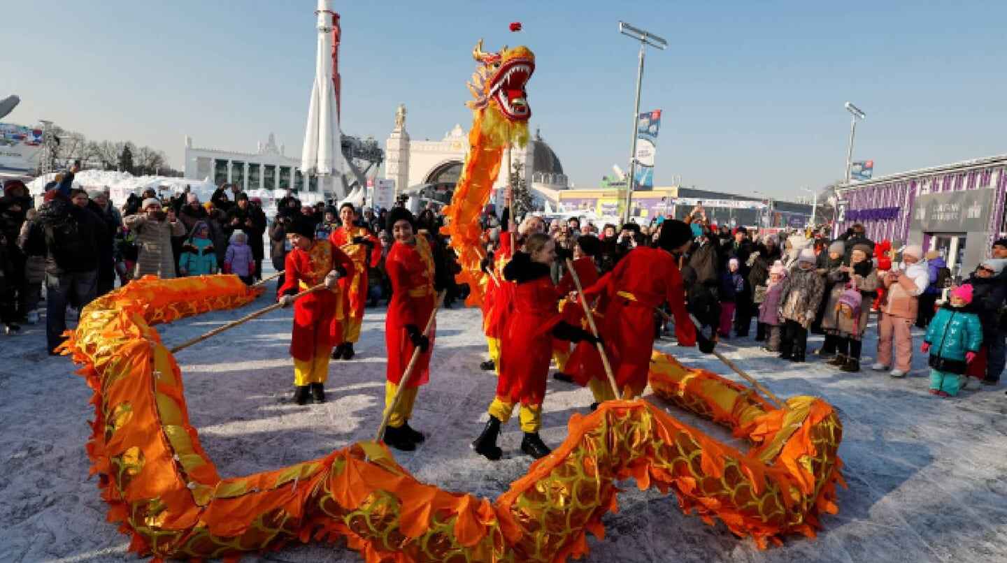Grupo de personas realizando un baile del dragón en una celebración al aire libre
