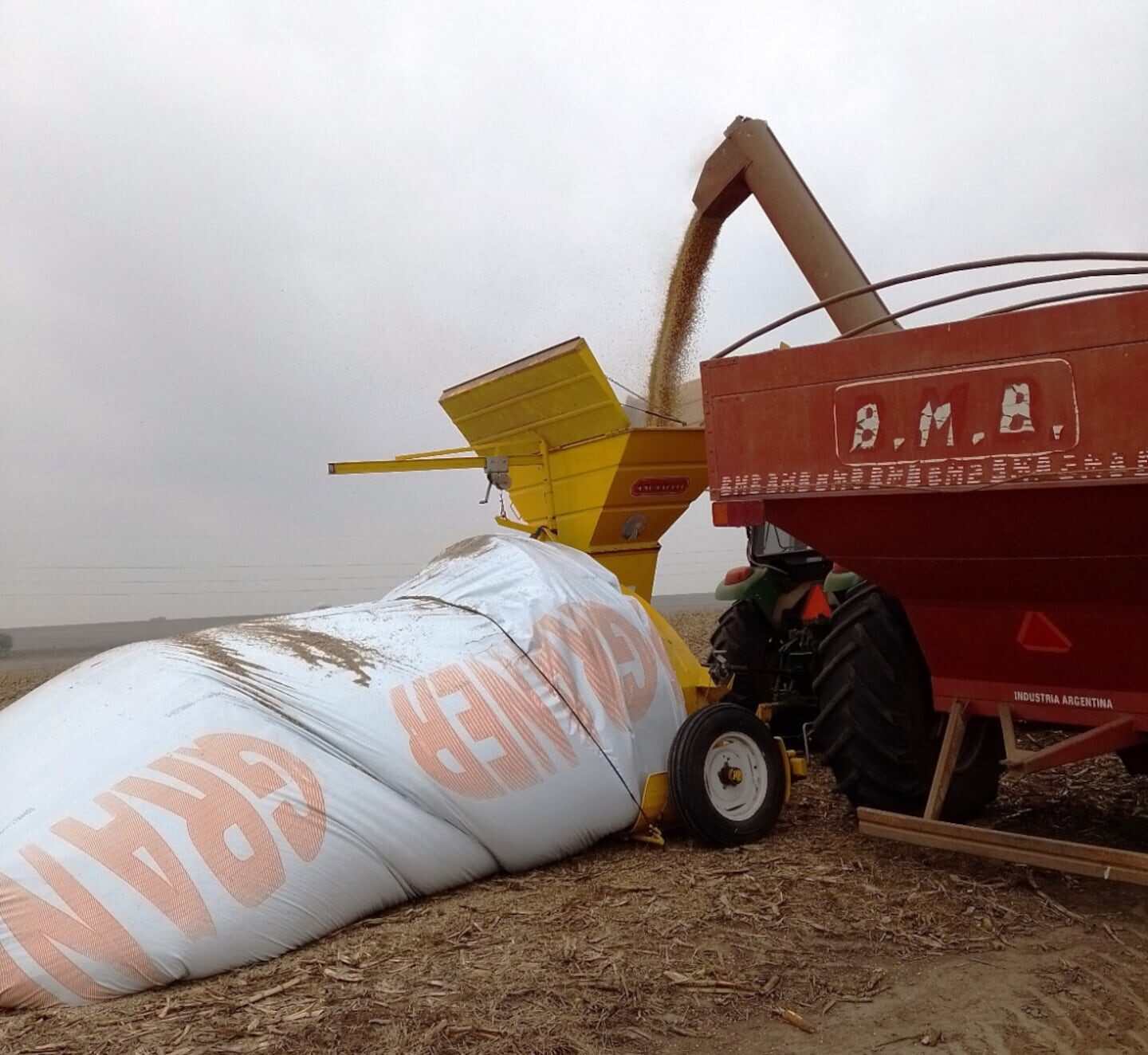 Tractor y maquinaria agrícola descargando granos en un campo de La Pampa