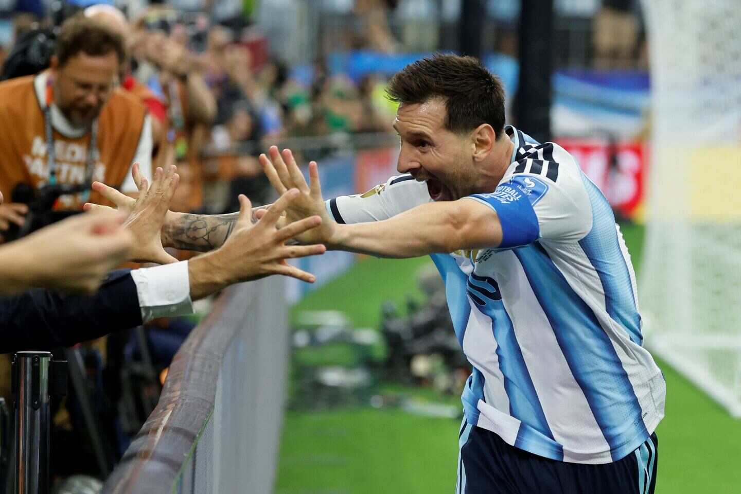 Lionel Messi celebra un gol y saluda a un periodista en el partido contra Austria