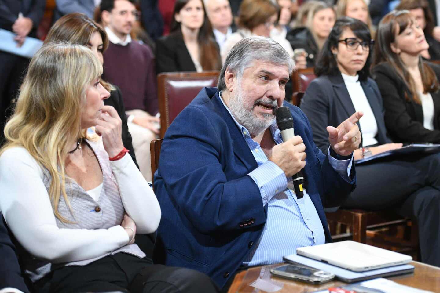 Manuel Adorni hablando en el Senado mientras es observado por otros asistentes