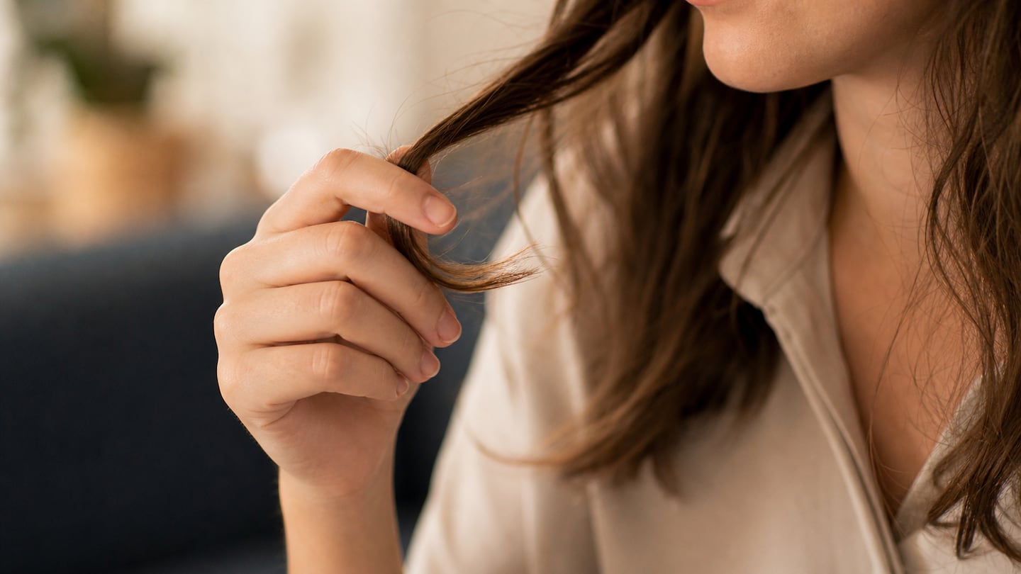 Mujer tocándose el pelo mientras habla, mostrando un gesto de nerviosismo