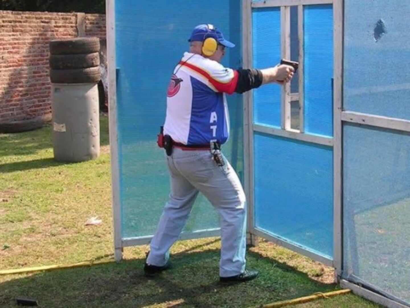 Hombre disparando en un campo de tiro con protección auditiva