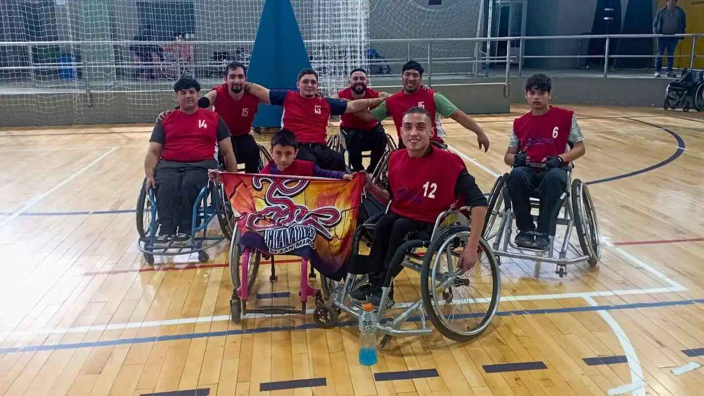Equipo de básquet adaptado con Agustín Torrales en el centro sosteniendo una bandera