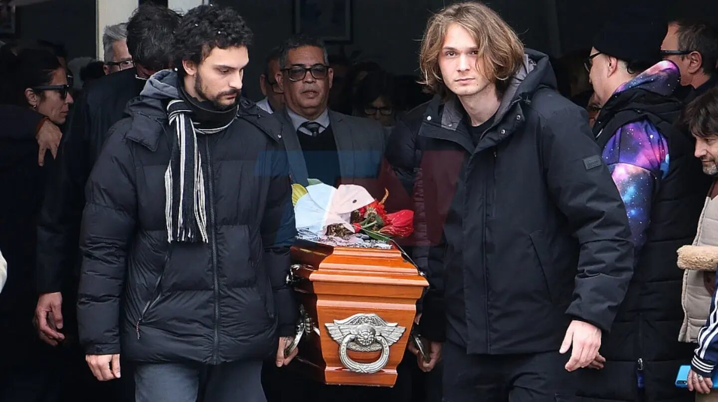 Dos hombres cargan un ataúd en un funeral