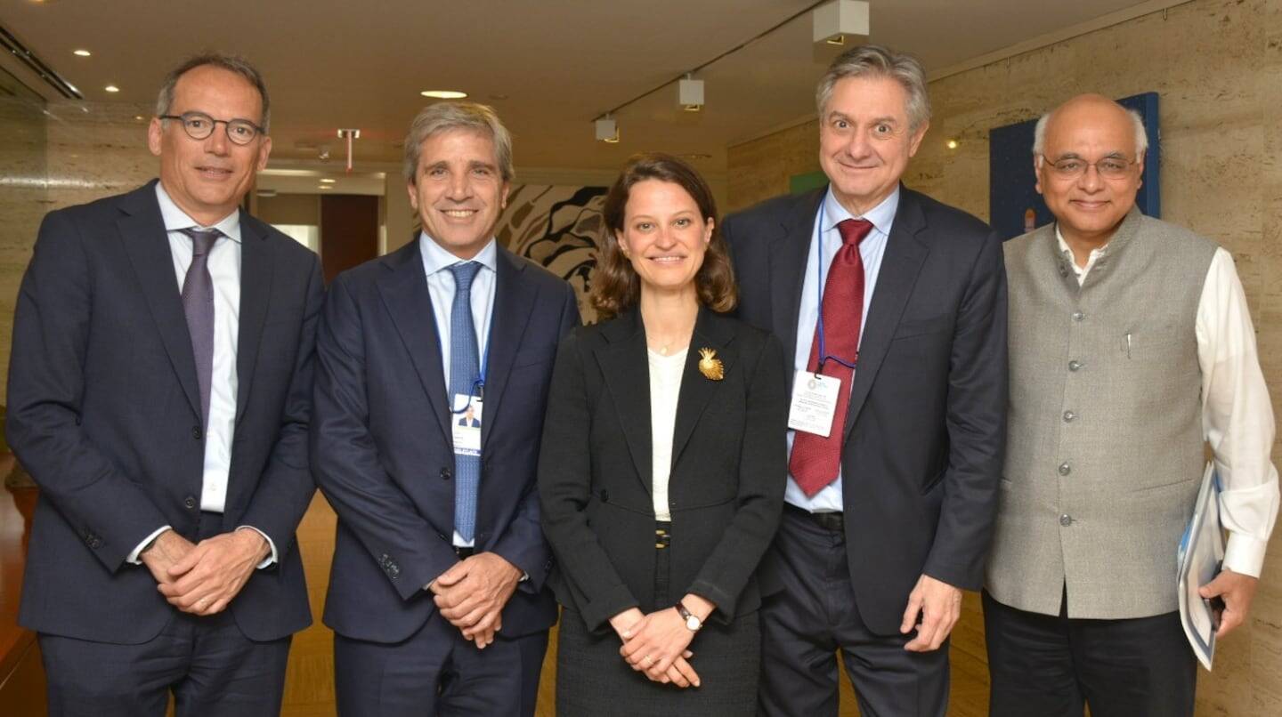 Grupo de cinco personas posando en un evento relacionado con economía y finanzas