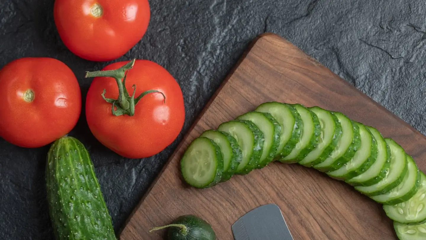 Rodajas de pepino y tomates frescos sobre una tabla de madera