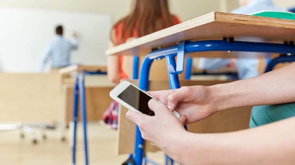Estudiantes en un aula con celulares