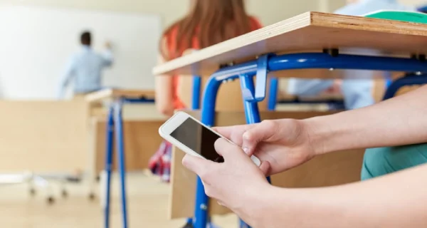Estudiantes en un aula con celulares