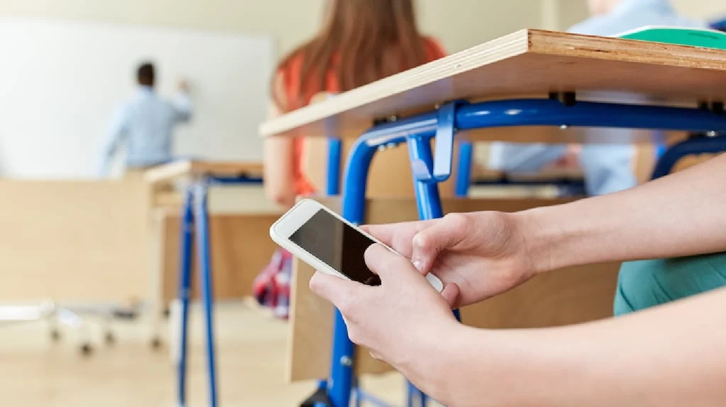 Estudiantes en un aula con celulares