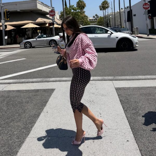 Emilia Mernes caminando por la calle con un atuendo de moda