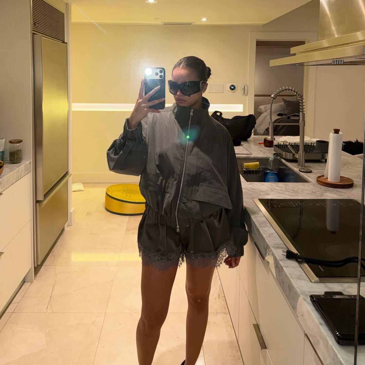 Emilia Mernes posando con un conjunto de bikini y chaqueta en una cocina moderna