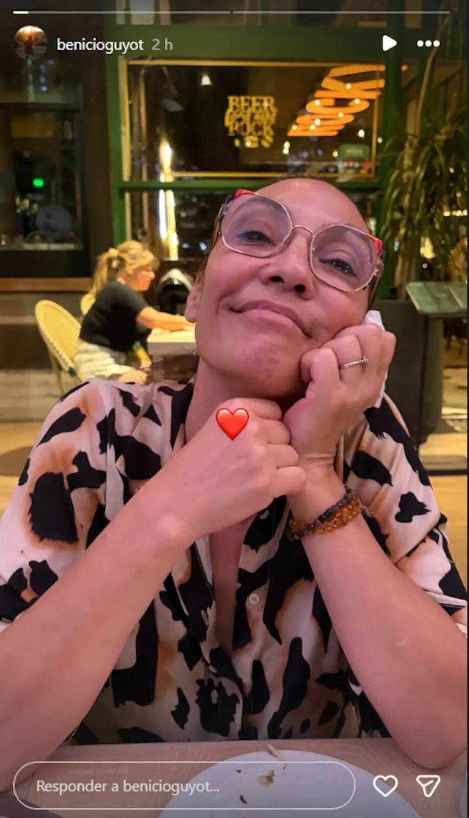 Ernestina Pais sonriendo con las manos en el rostro en un ambiente acogedor