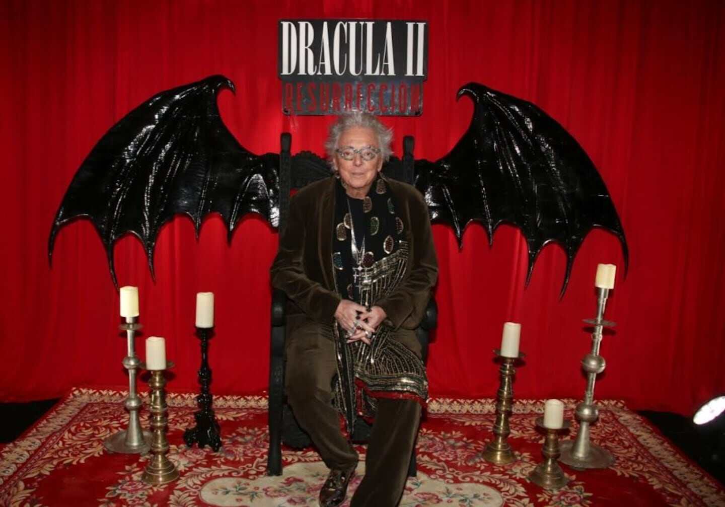 Pepe Cibrián Campoy en el estreno de 'Drácula 2 Resurrección' con fondo rojo y alas de murciélago