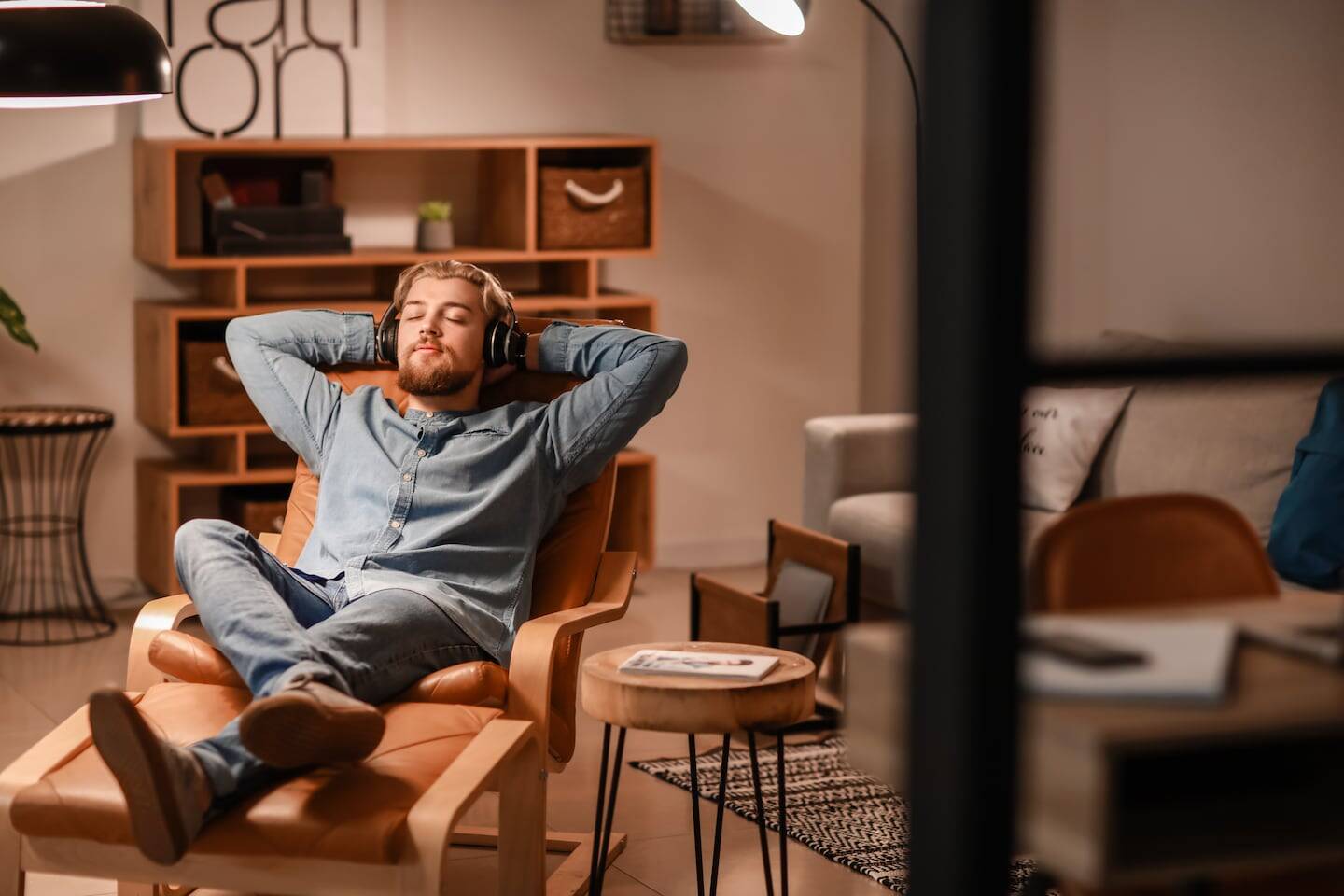 Hombre relajándose con auriculares en un ambiente acogedor