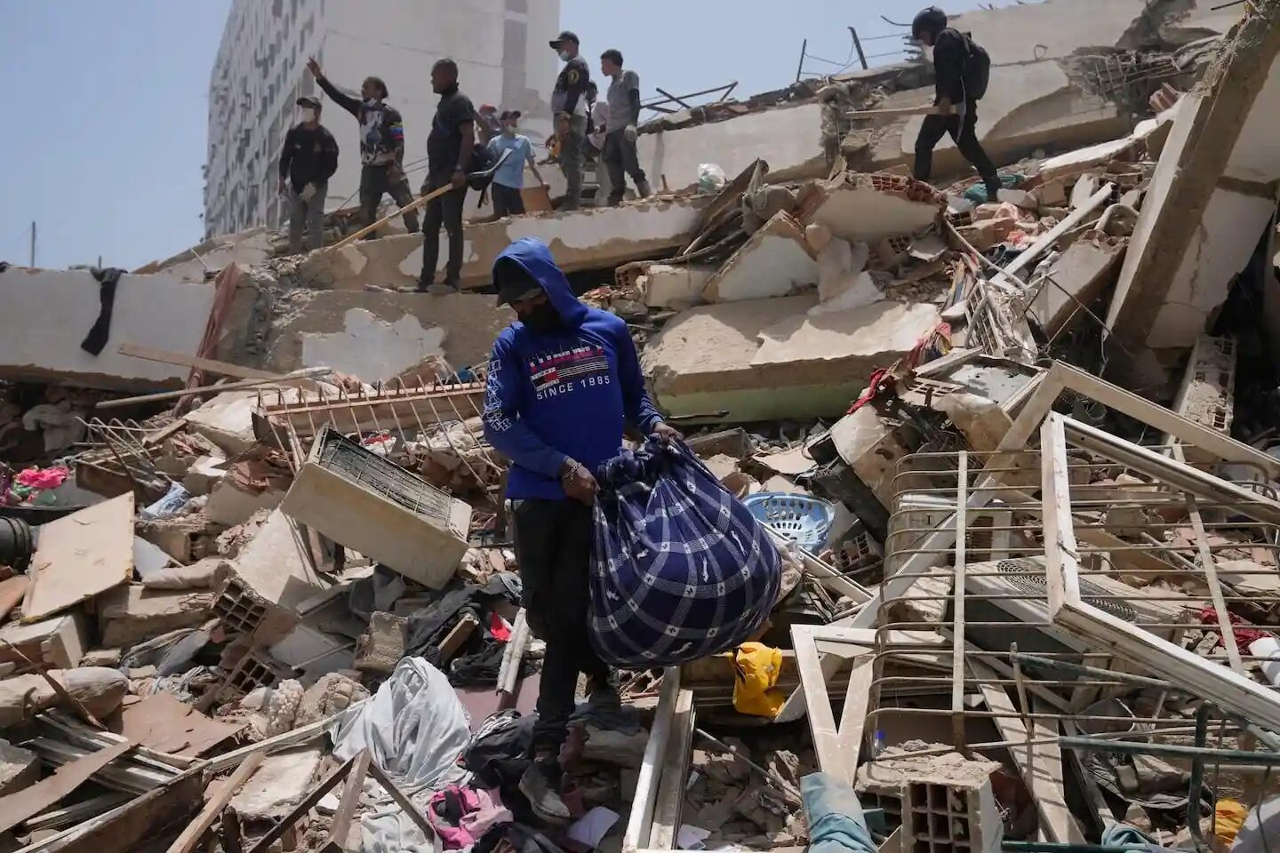 Persona con una mochila sobre escombros tras un terremoto en Venezuela