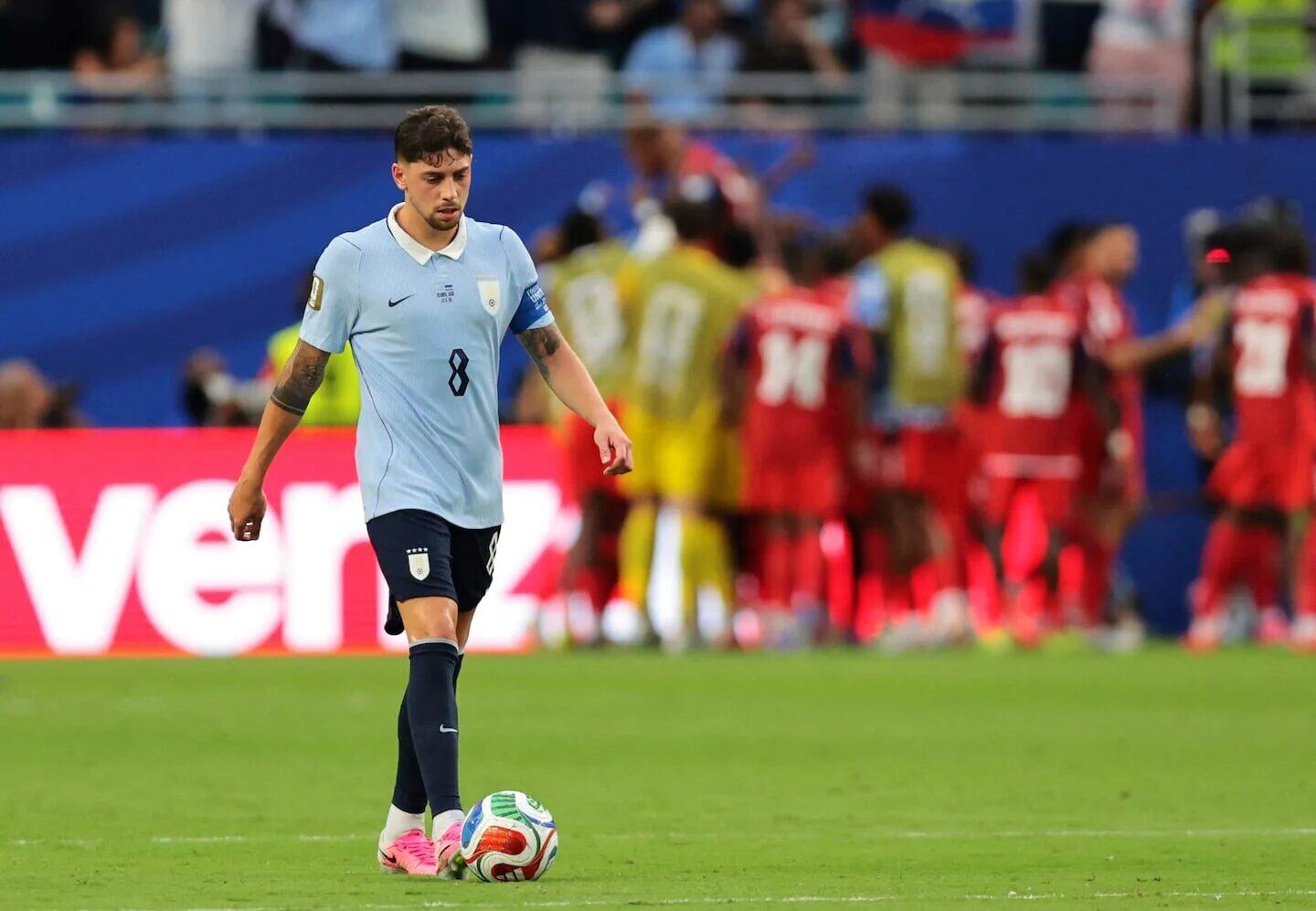 Federico Valverde caminando cabizbajo tras ser reemplazado en un partido de fútbol