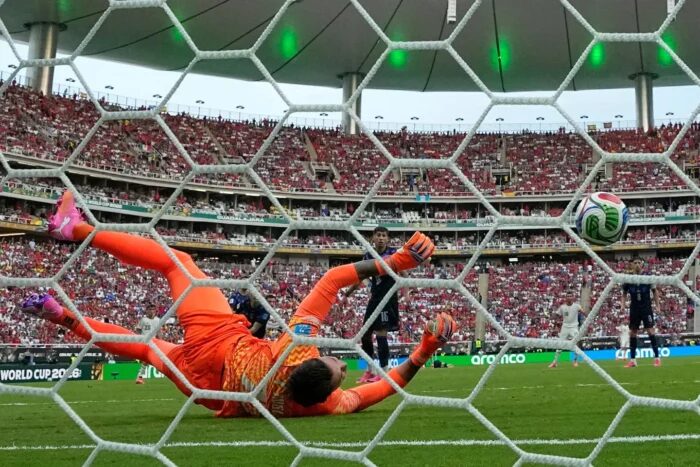 Fernando Muslera en acción durante un partido de fútbol, intentando detener un gol
