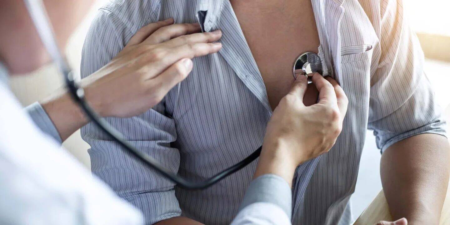 Médico auscultando el corazón de un paciente con un estetoscopio
