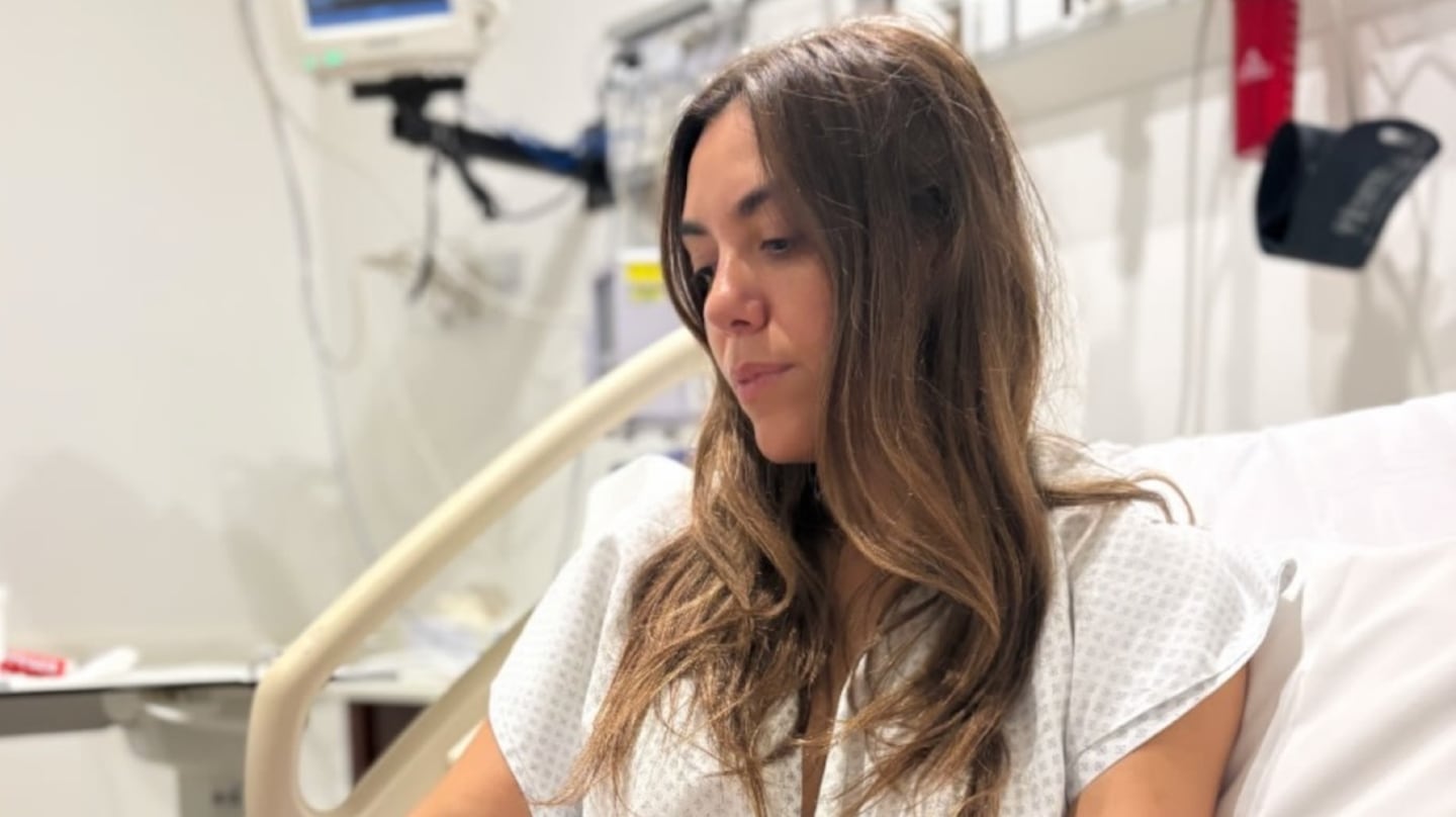 Floppy Tesouro en una cama de hospital, mirando hacia abajo con expresión pensativa