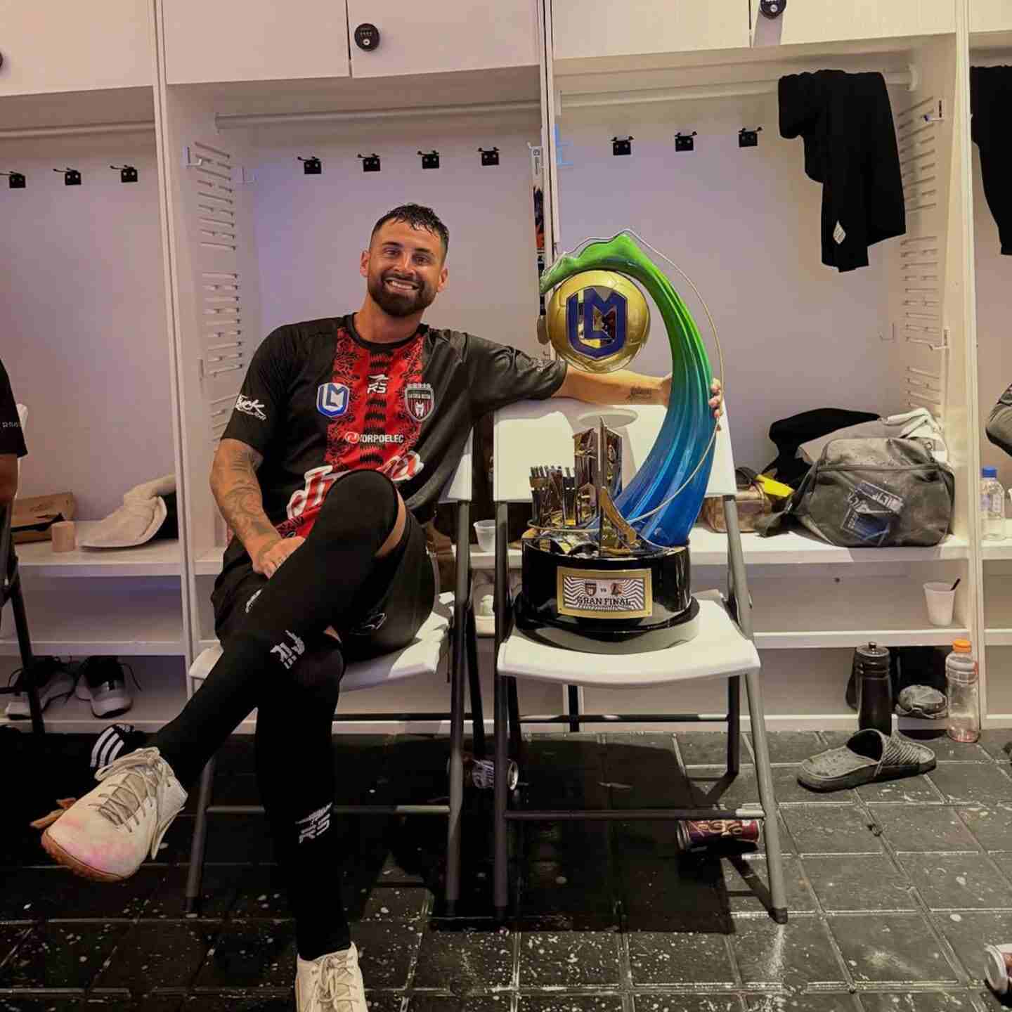 Lucas Trejo, futbolista argentino del Club Sport Marítimo, posando con un trofeo en el vestuario