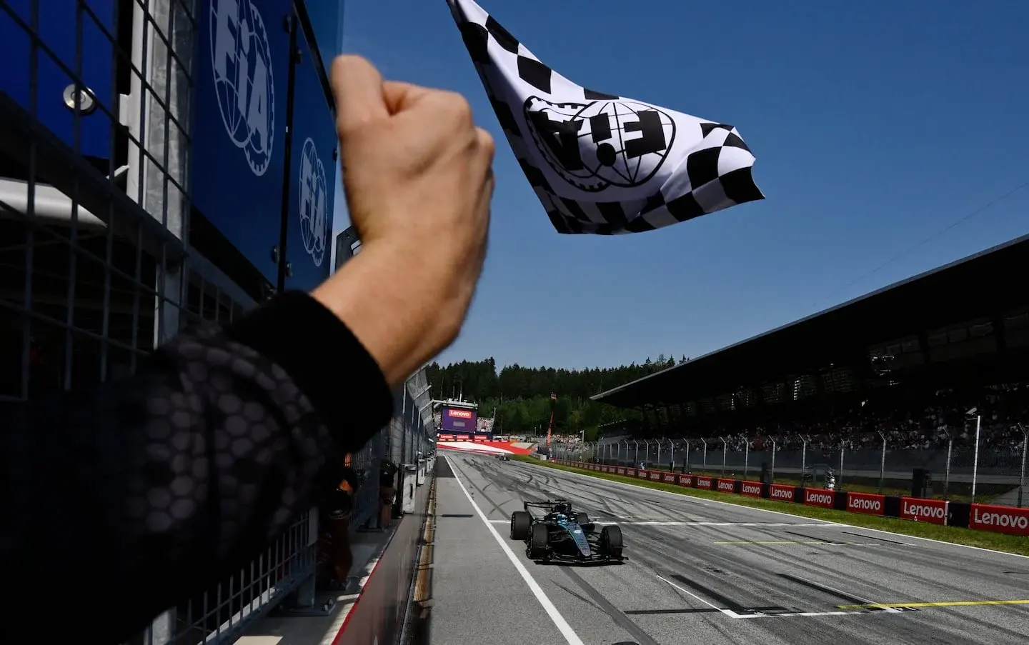 George Russell cruza la meta en el Gran Premio de Austria mientras se ondea la bandera a cuadros