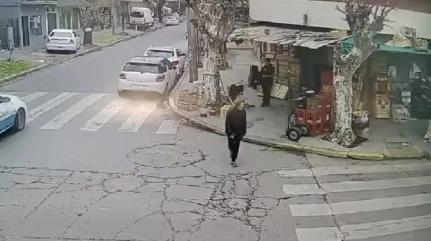 Una mujer caminando por la calle en San Justo, cerca de un quiosco