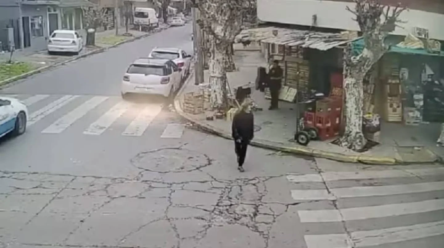 Una mujer caminando por la calle en San Justo, cerca de un quiosco