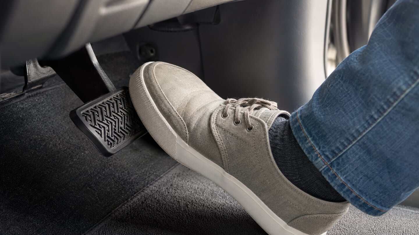 Pie presionando el pedal de freno en un vehículo