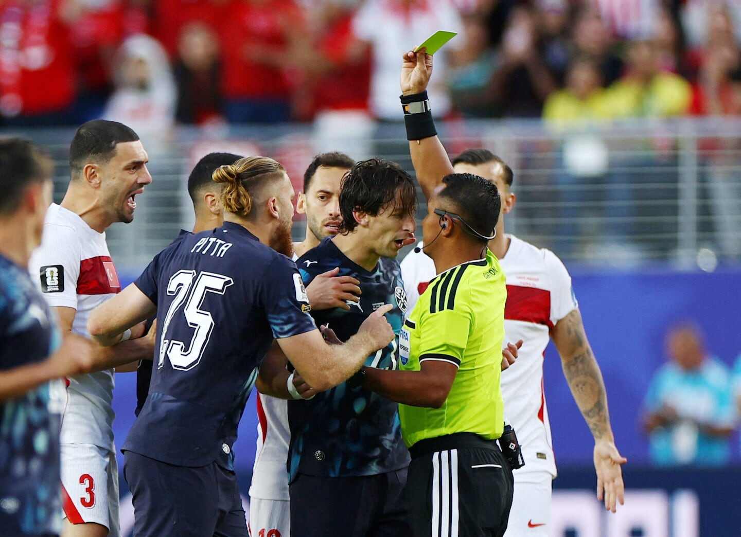Futbolista paraguayo Matías Galarza discutiendo con el árbitro mientras recibe una tarjeta amarilla