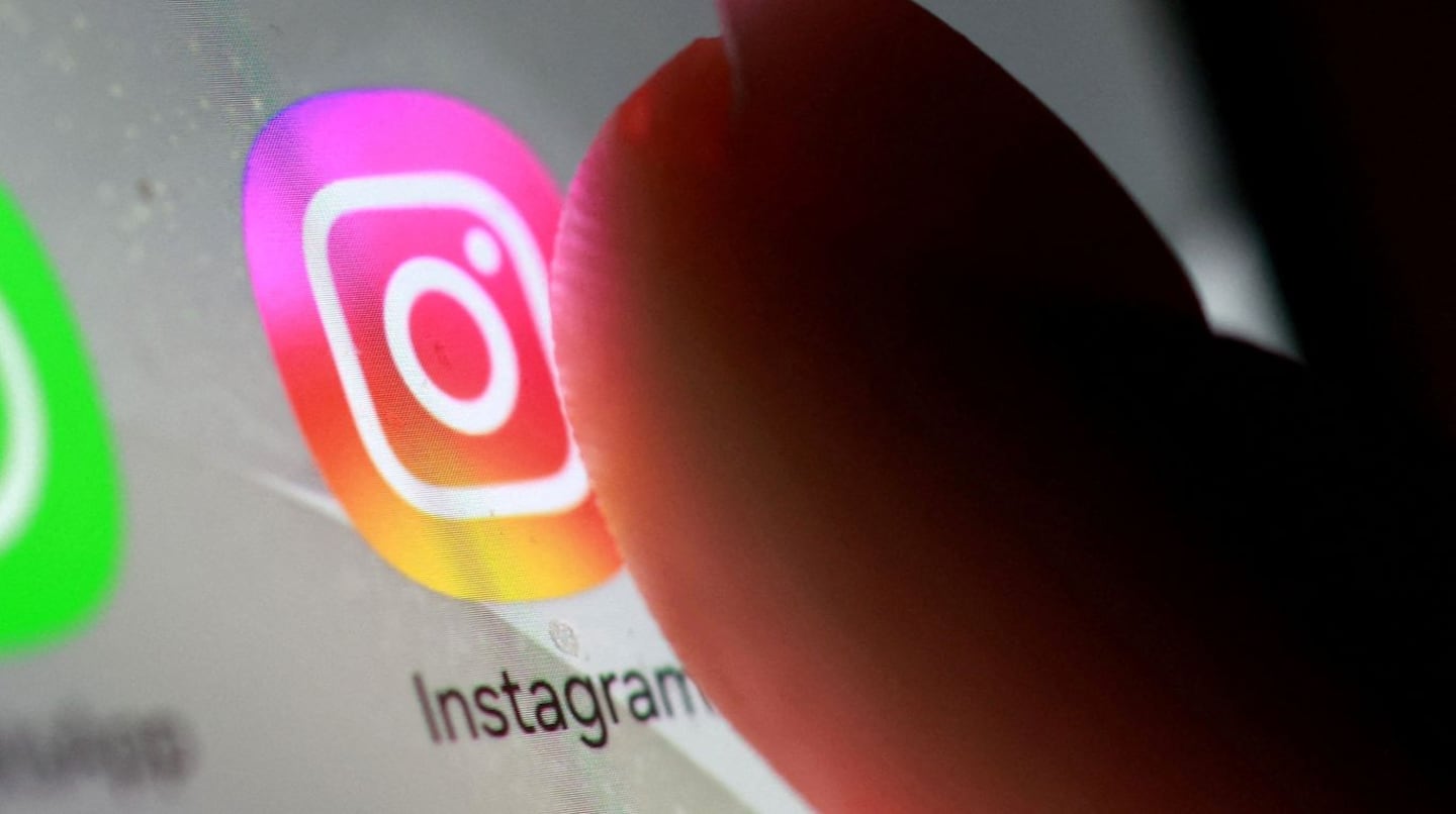 Un dedo tocando el ícono de Instagram en una pantalla de teléfono móvil