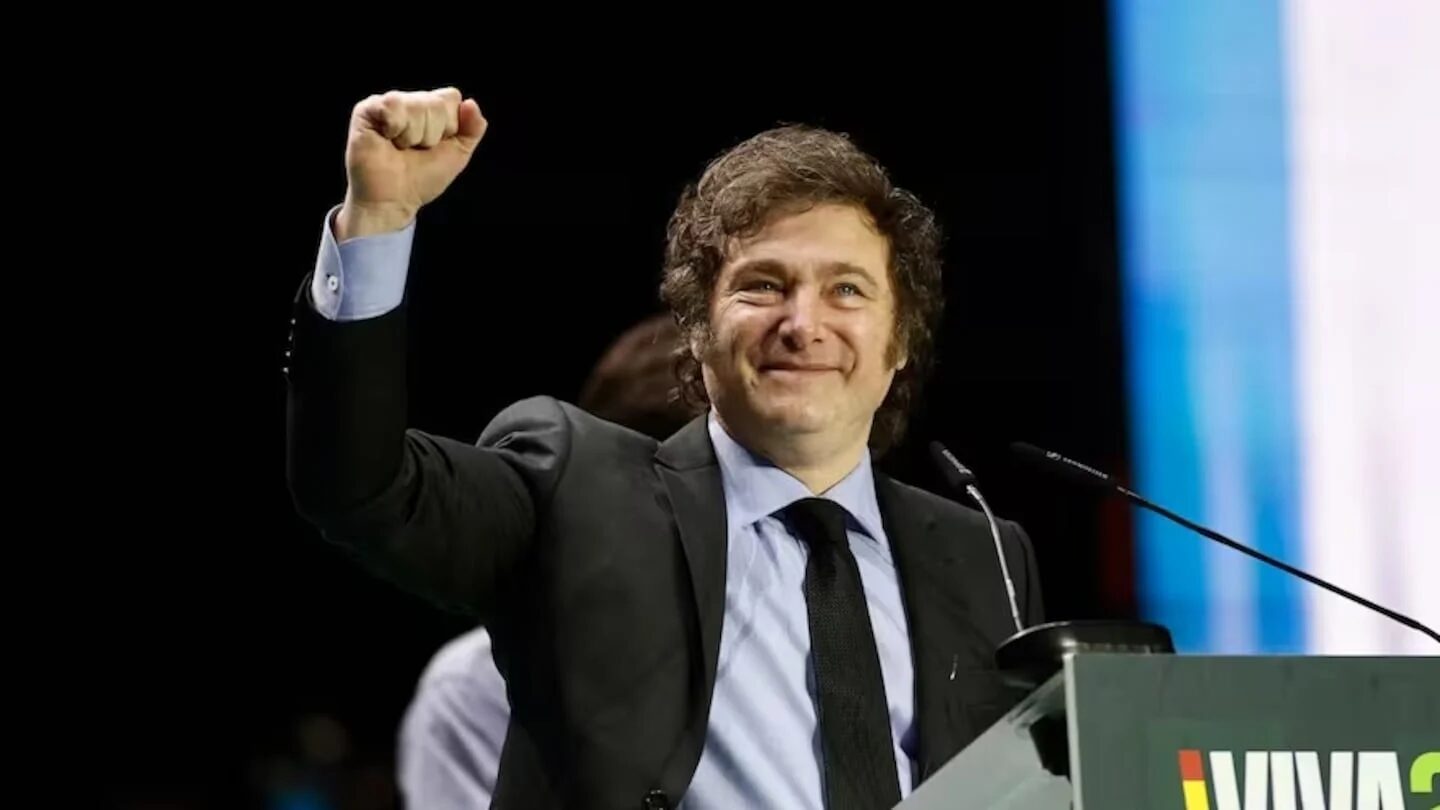 Javier Milei levantando el puño en un evento en España