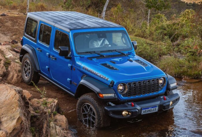 Jeep Wrangler azul atravesando un terreno accidentado