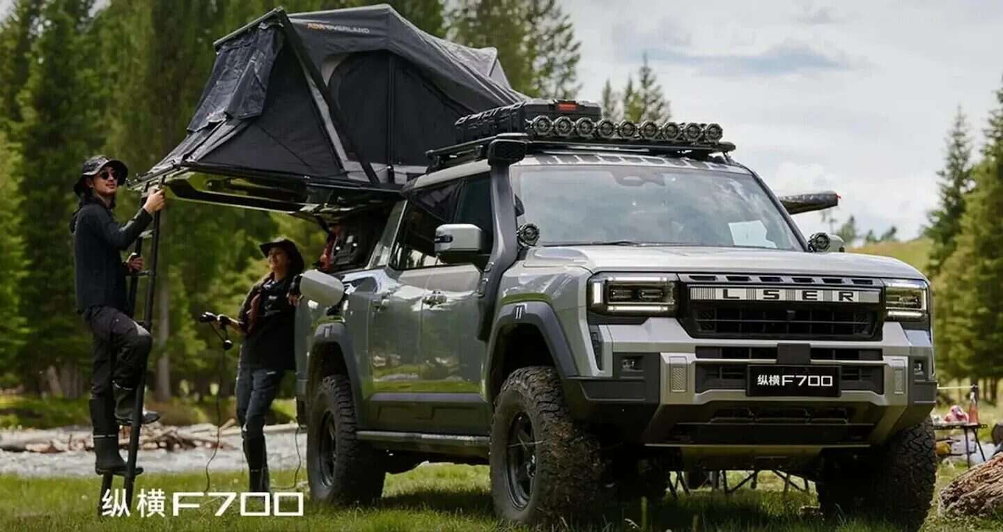 Pick up híbrida enchufable Jetour Zongheng F700 en un entorno natural con accesorios de camping