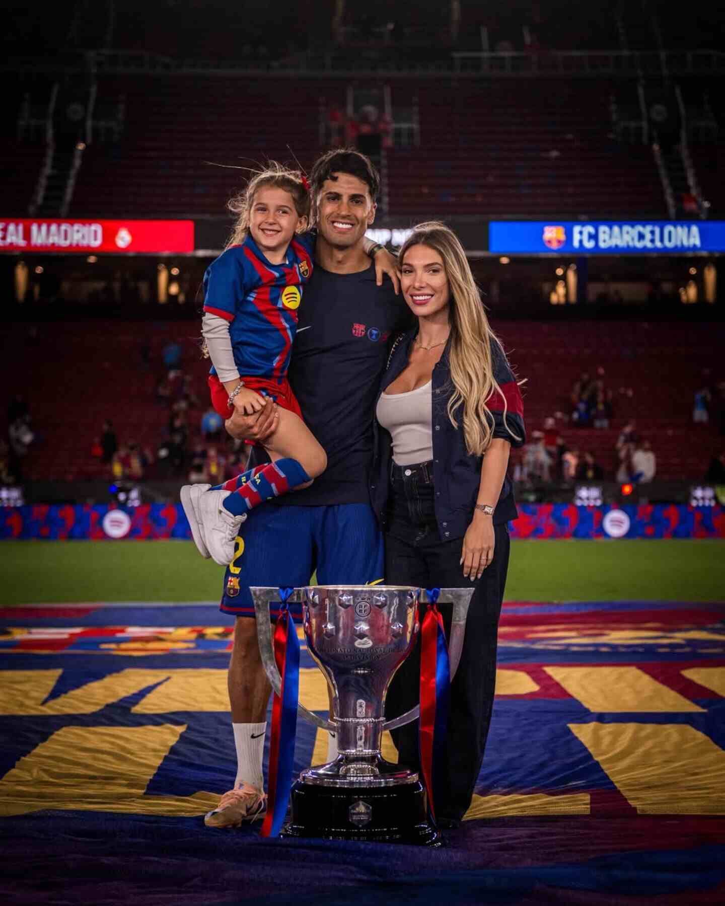 Joao Cancelo posando con su hija y pareja tras ganar un trofeo en el estadio del FC Barcelona