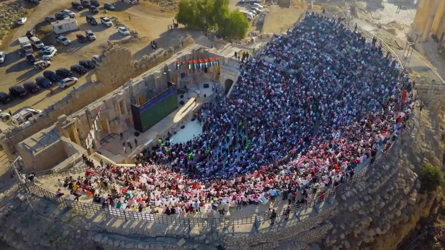 Vista aérea de un gran evento en un antiguo teatro romano en Jordania con una multitud reunida