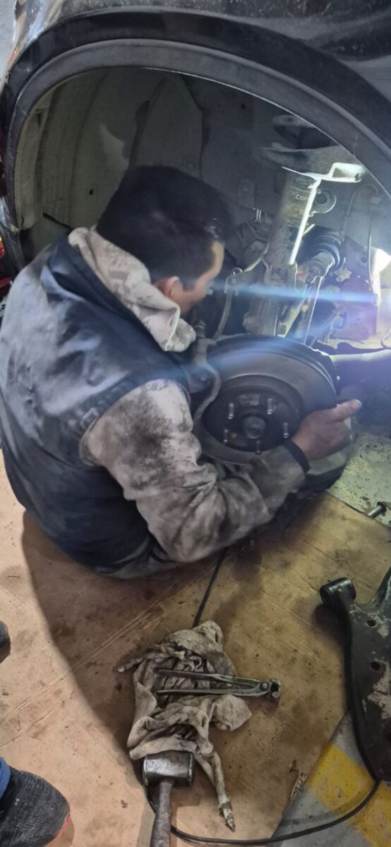 Julio Inostroza trabajando en su taller mecánico en Comodoro Rivadavia