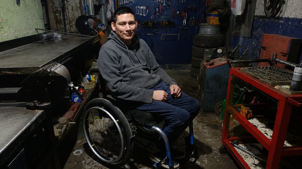 Julio Inostroza trabajando en su taller de mecánica