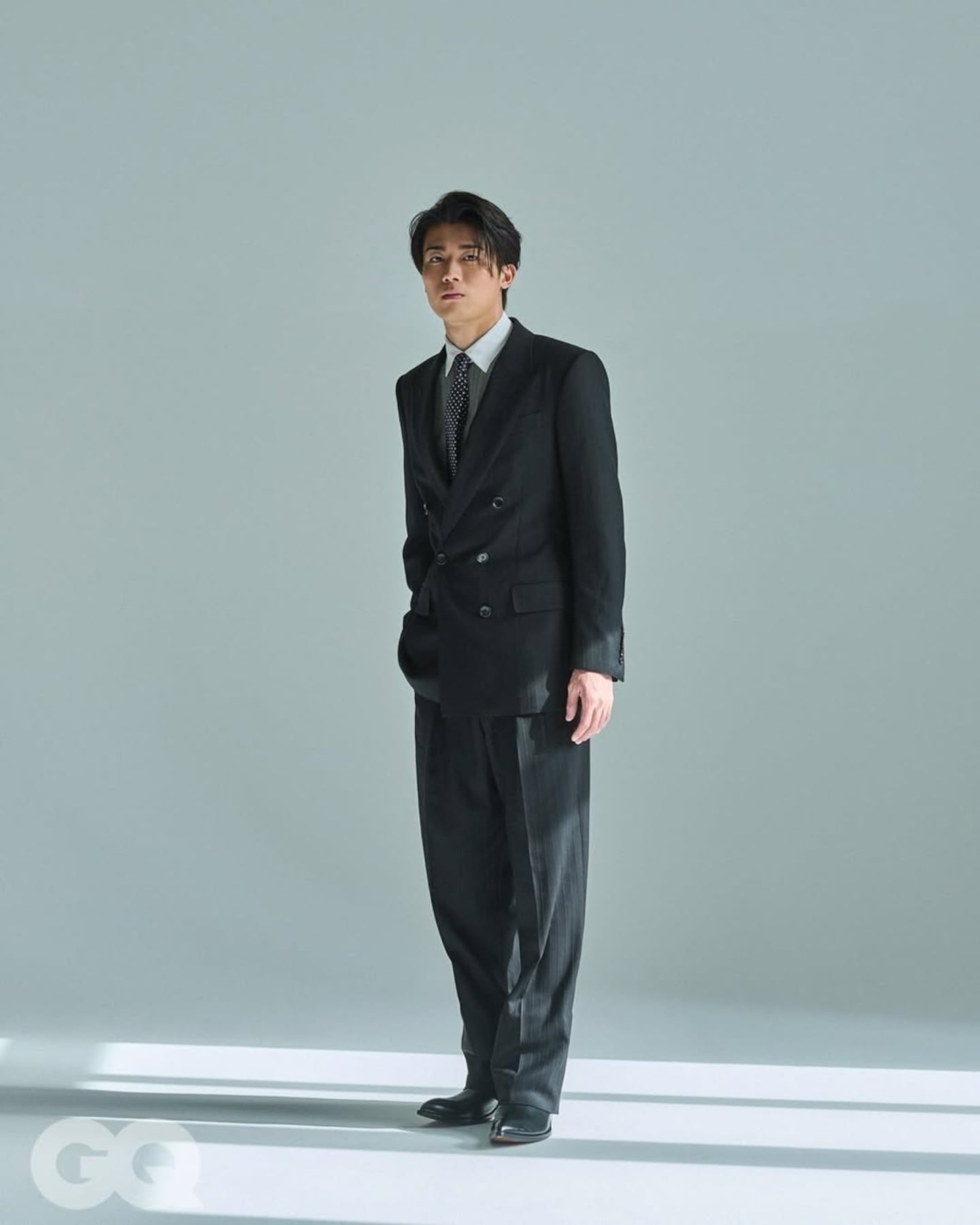 Keito Nakamura posando con un traje elegante en un fondo minimalista